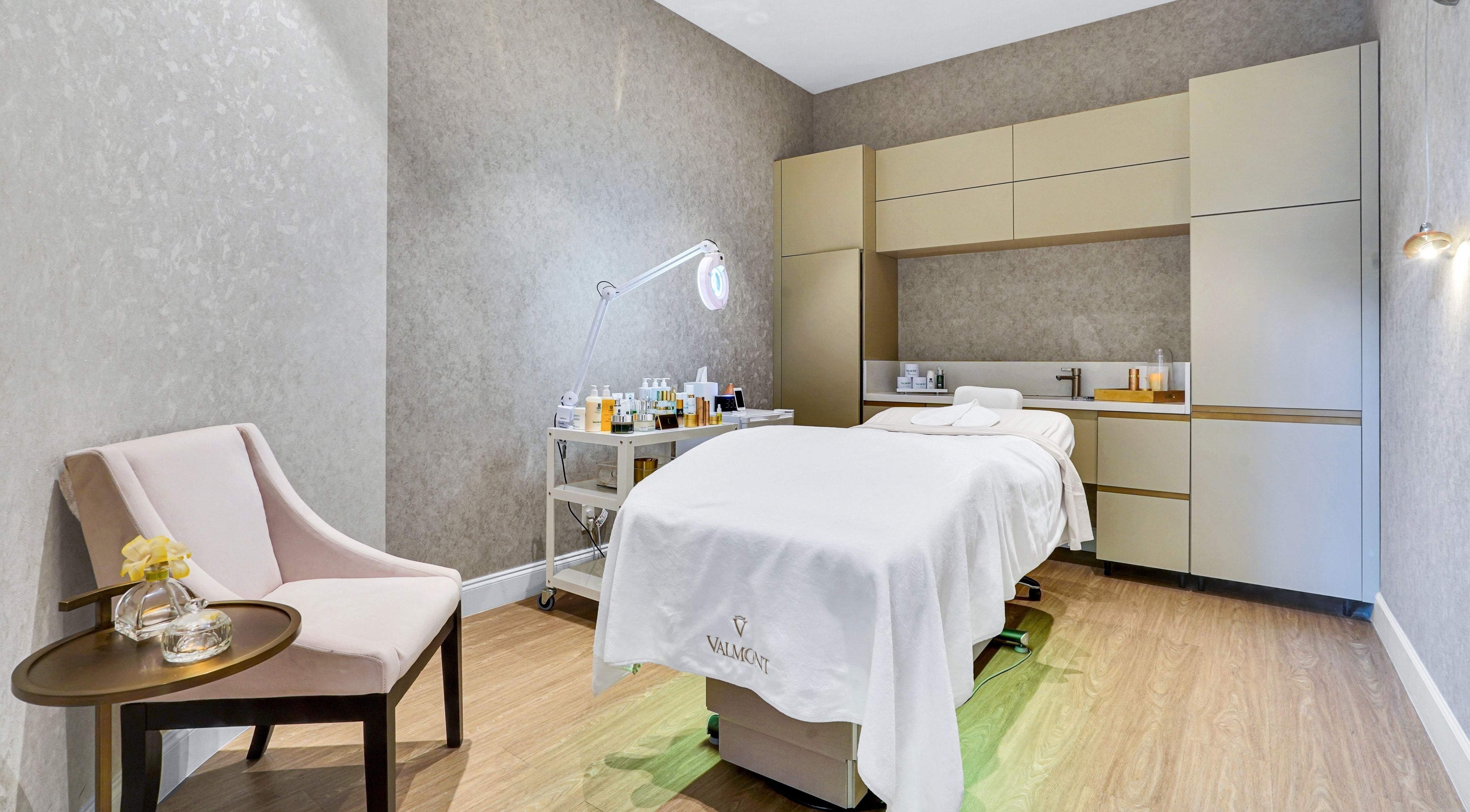 Tranquil spa room at Beauty Ambassade and Spa in West Palm Beach, Florida, US. Luxe treatment bed and soft lighting.