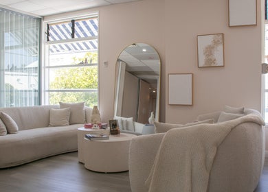 Cozy lounge area at Reborn Lash Boutique | Sanctuary Cove, Gold Coast, Queensland, AU with plush sofas and decor.