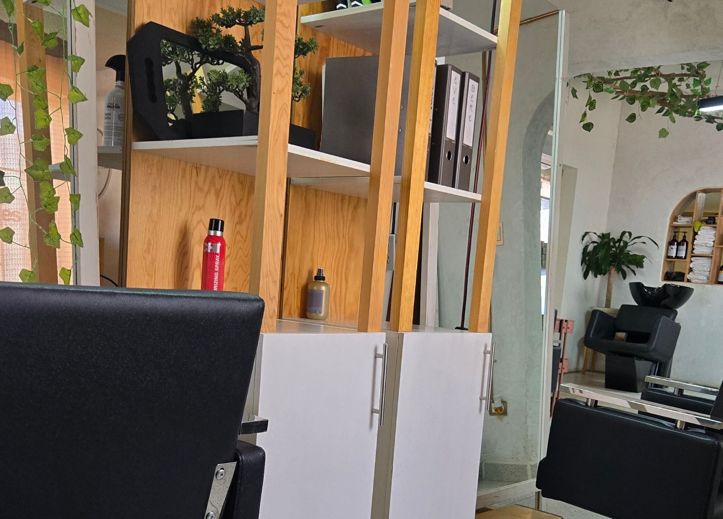 Interior elegante de Pastiche Studio en Chihuahua, Chihuahua, MX, presenta sillas negras y decoración natural.