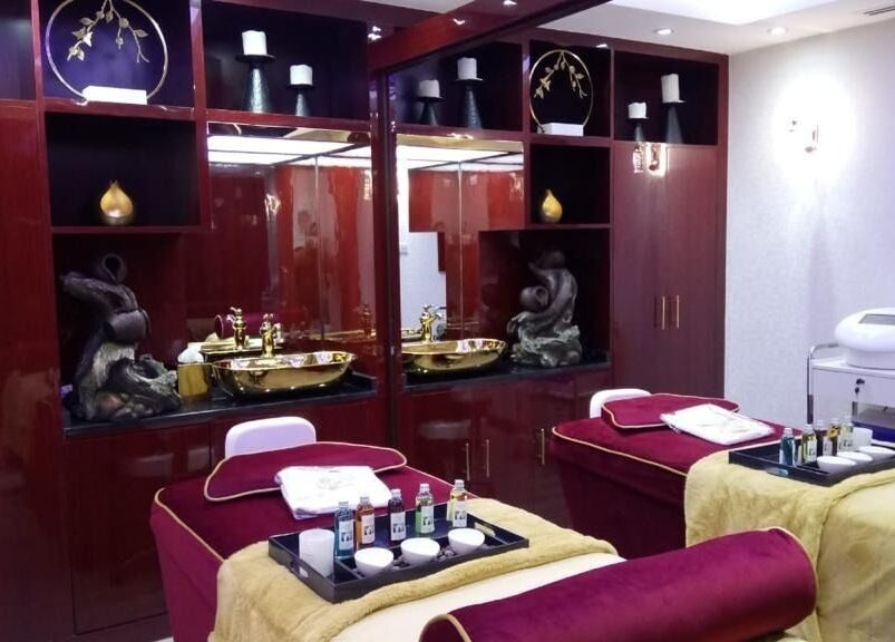 Elegant treatment room at The One and Only Madhu Beauty Lounge in Ajman, Ajman, AE with plush beds and gold accents.