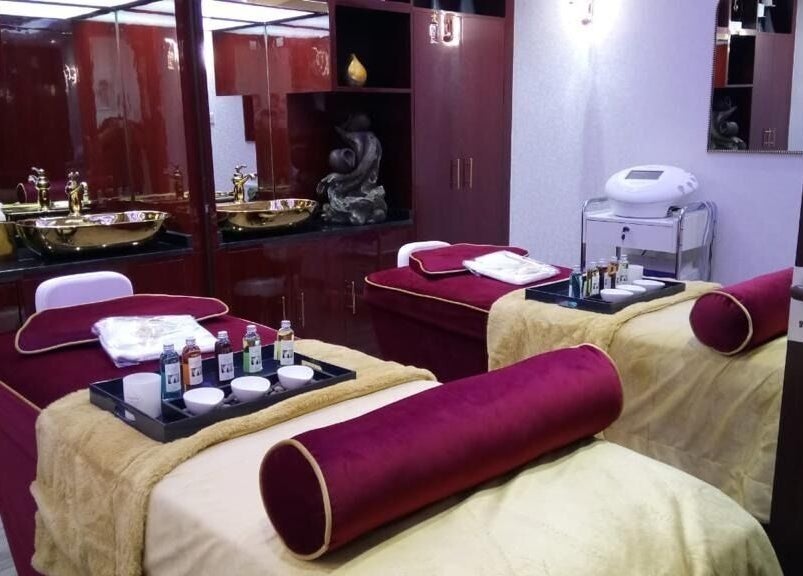 Elegant spa room at The One and Only Madhu Beauty Lounge, Ajman, AE, featuring plush treatment beds.
