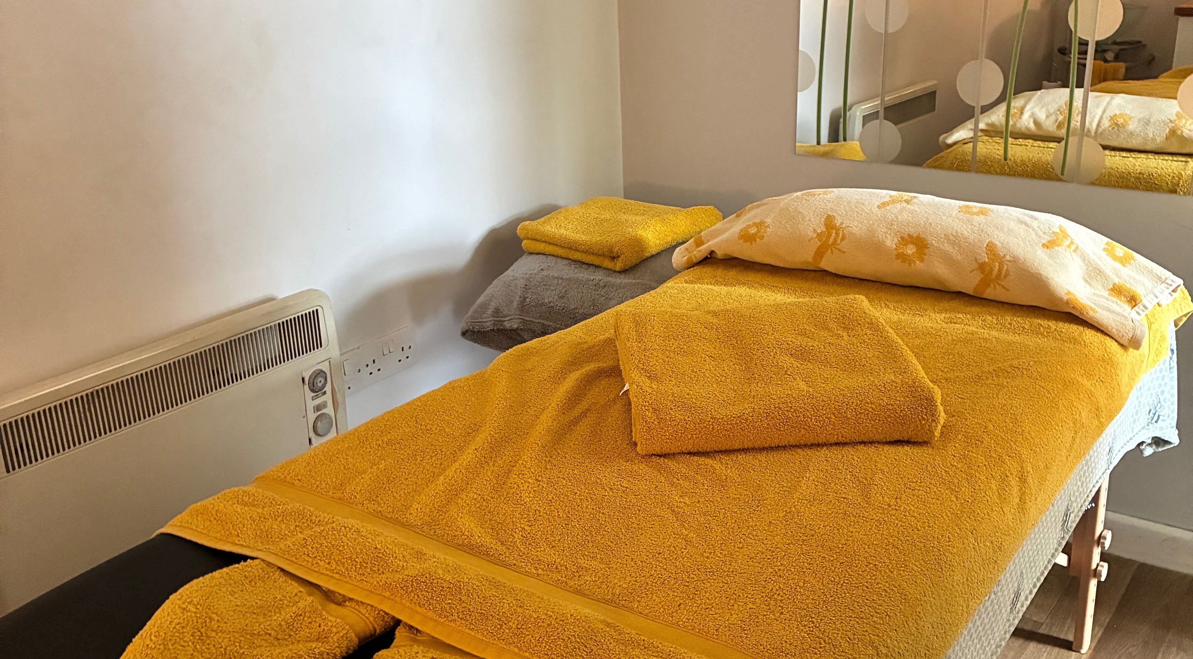 Massage table in Tranquil Fields at Farrington Gurney, England, GB, with yellow towels for a serene ambiance.