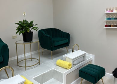 Luxurious pedicure area at Enhance Aesthetics, Canaan, Tobago, TT with plush chairs and nail polish display.