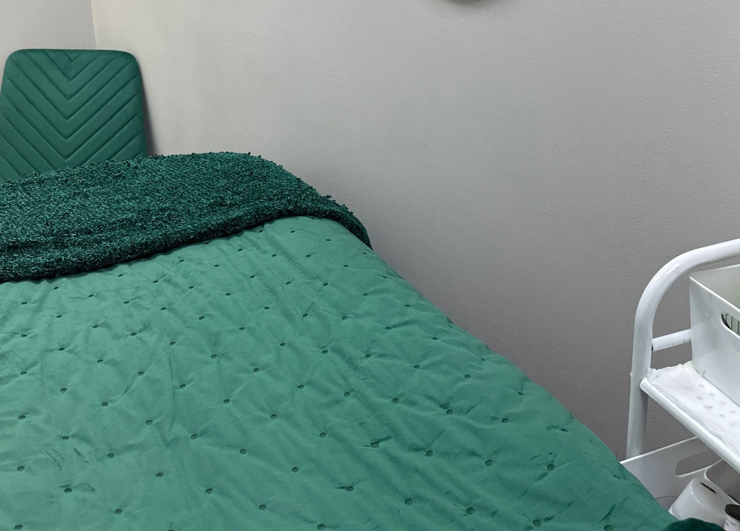 Relaxing treatment room at Blossom Health and Beauty, Great Shelford, England, GB, with green bedspread.