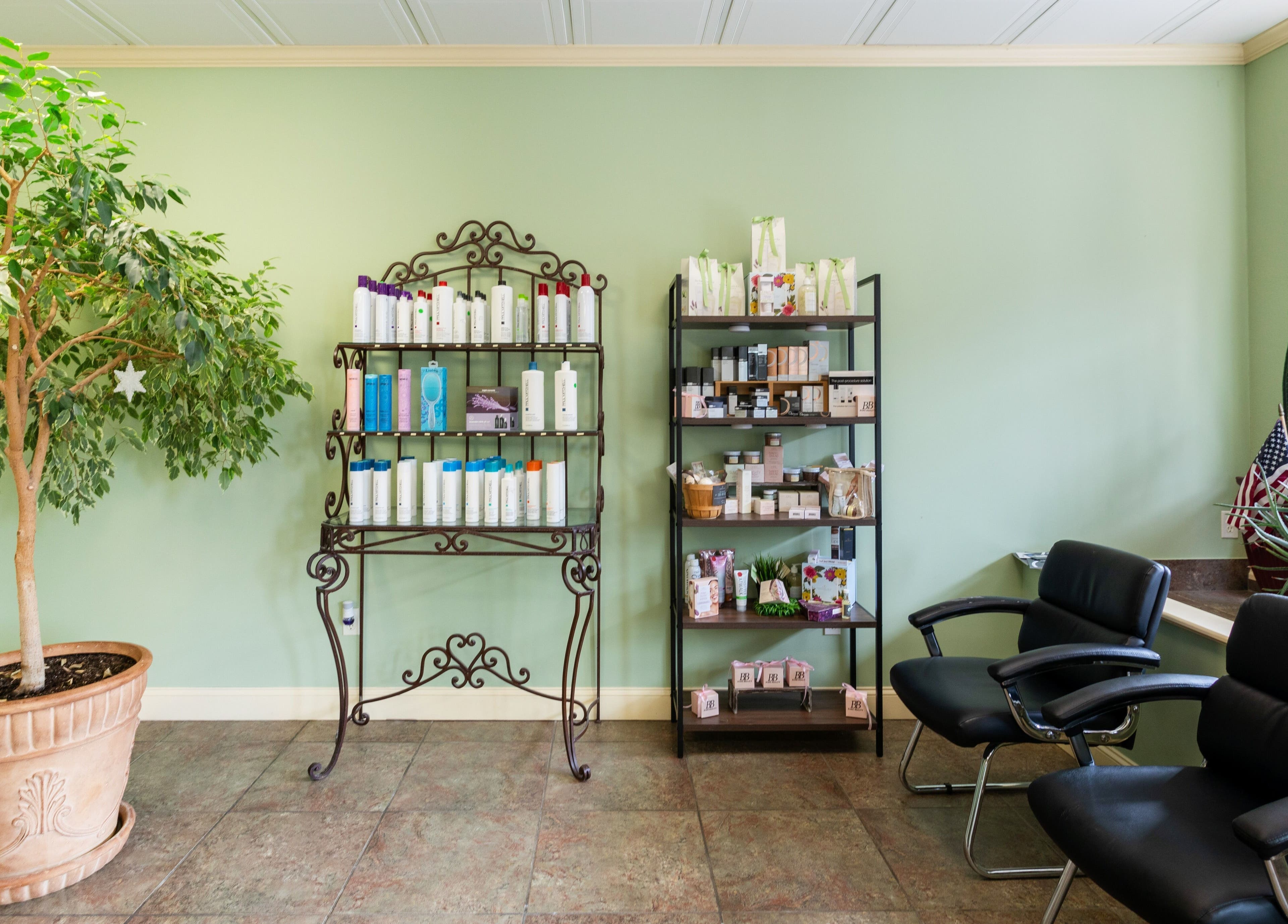 Cozy waiting area at Bare Beauty Aesthetics, Ludlow, Massachusetts, with shelves of products and lush plants.