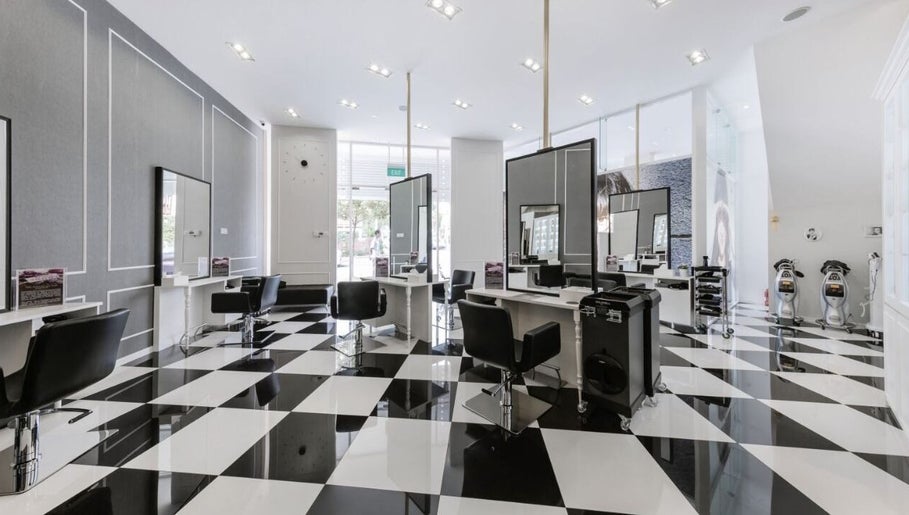 Elegant black and white salon interior at Salon de Edmund, Singapore, Bishan, SG showcasing modern styling stations.