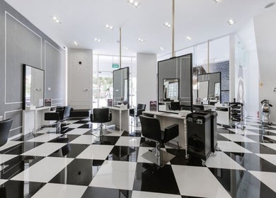 Elegant black and white salon interior at Salon de Edmund, Singapore, Bishan, SG showcasing modern styling stations.