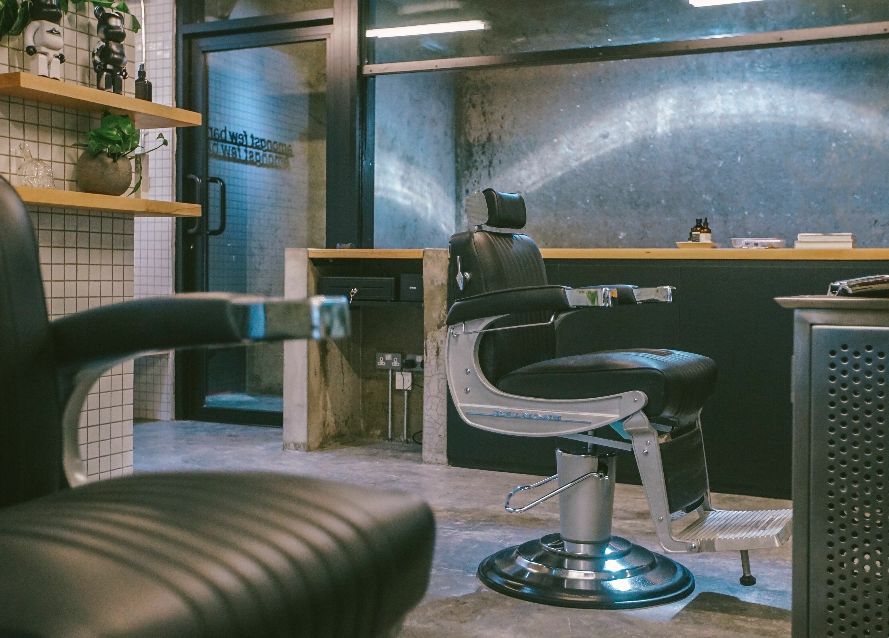 Modern interior of Amongst Few Barber in دبي, دبي, AE with sleek black chairs and contemporary decor.