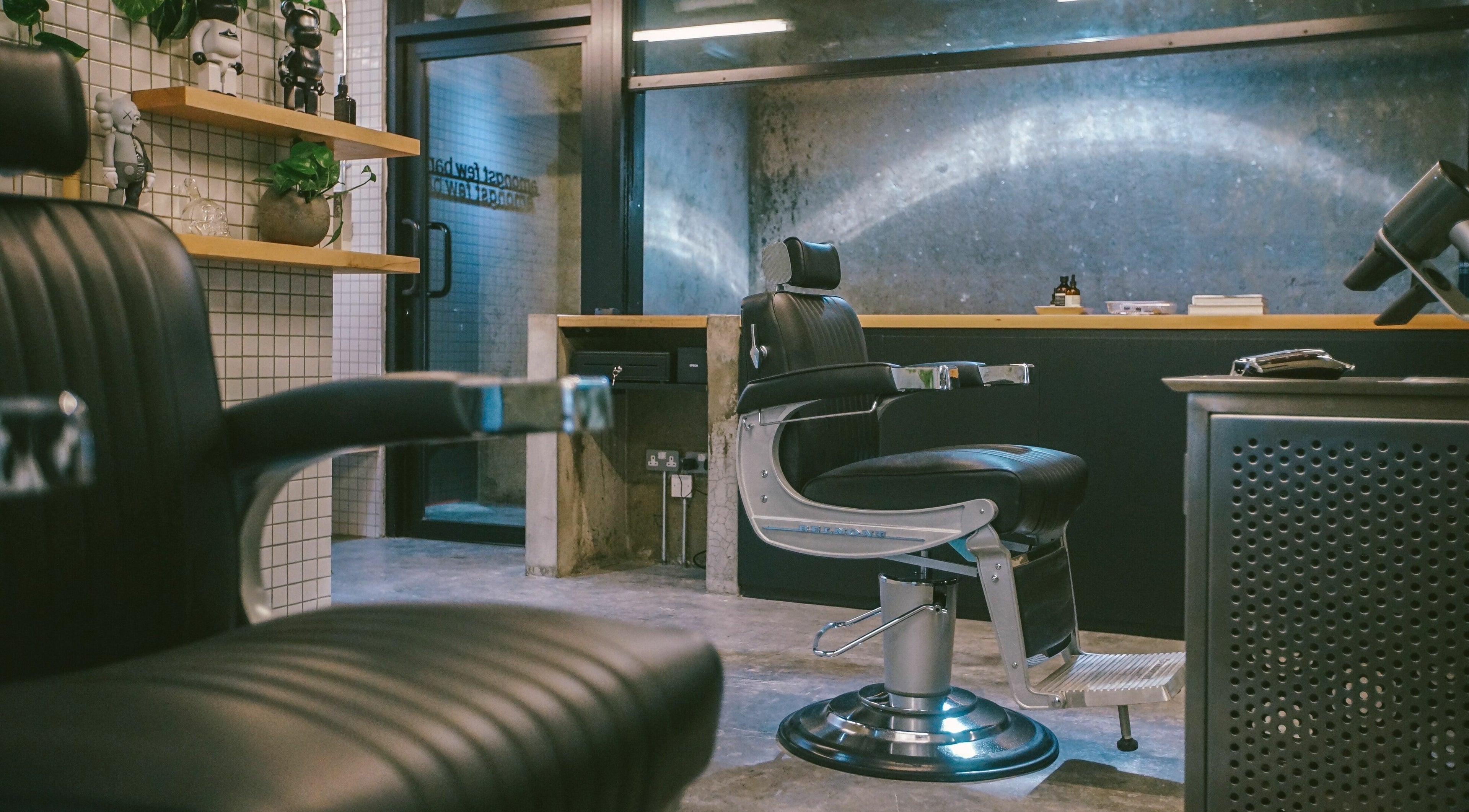 Modern interior of Amongst Few Barber in دبي, دبي, AE with sleek black chairs and contemporary decor.