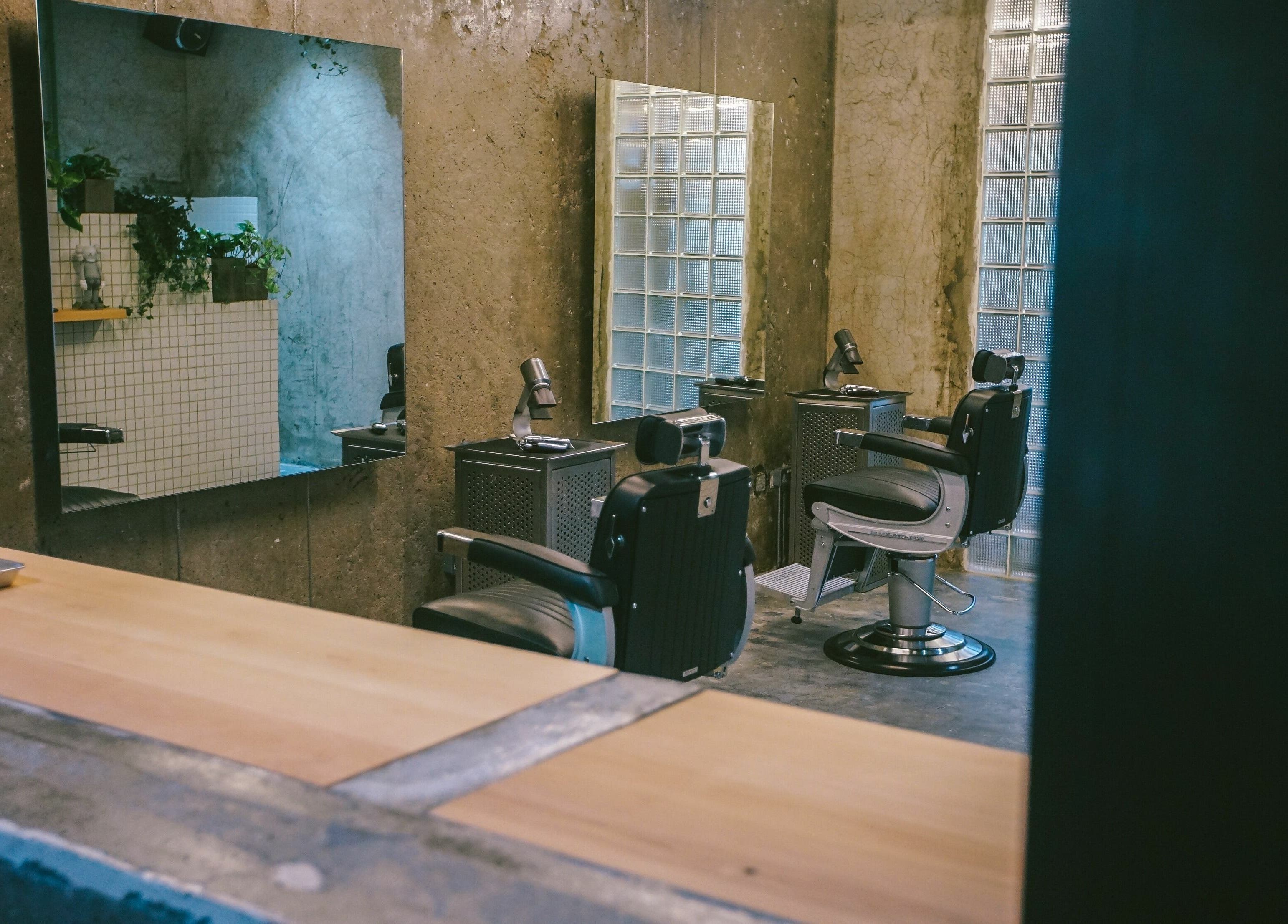 Modern barber chairs and mirrors at Amongst Few Barber, دبي, دبي, AE, offering a chic grooming experience.