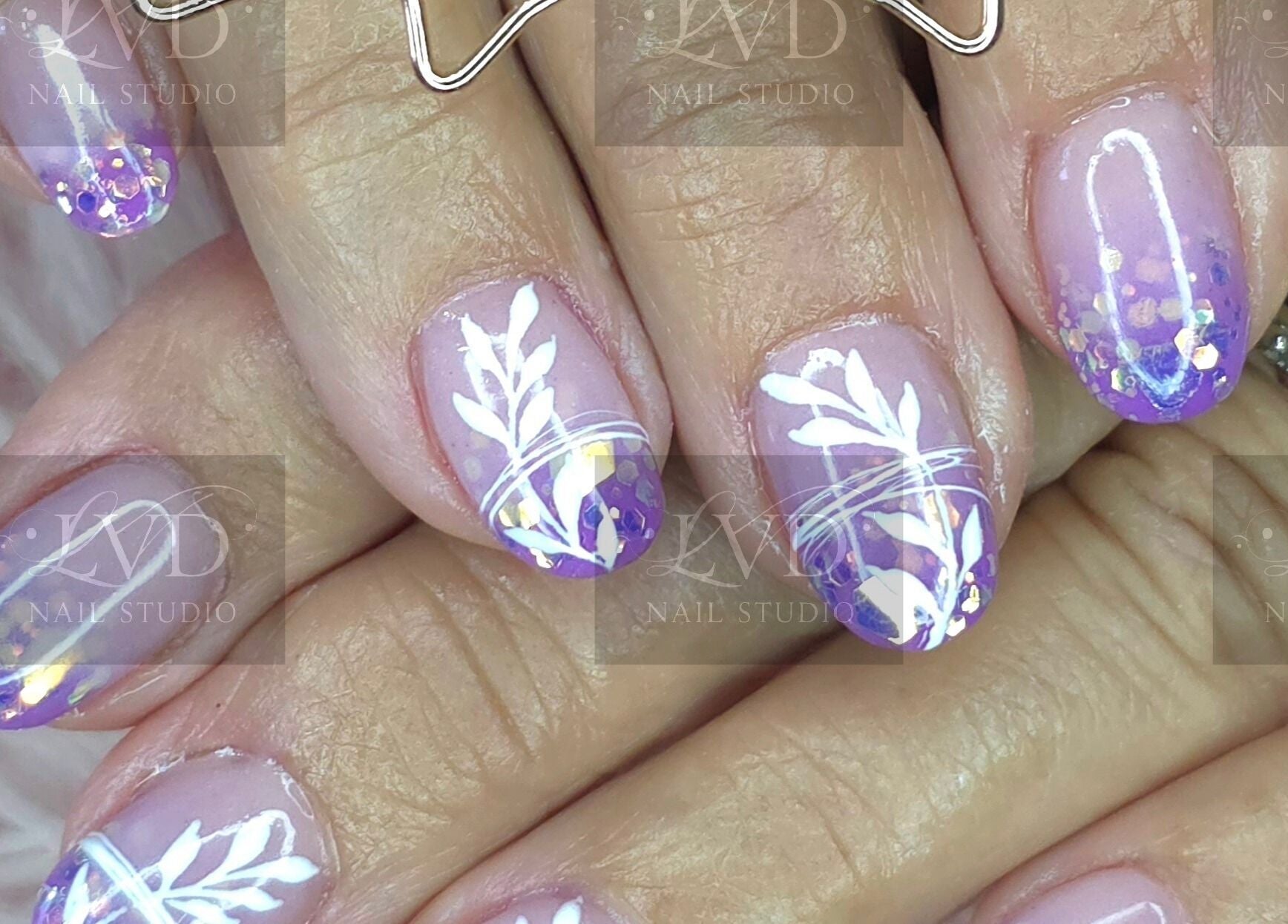 Vibrant nail art at LVD NAIL STUDIO in Pretoria, Gauteng, ZA, featuring purple and white floral design.