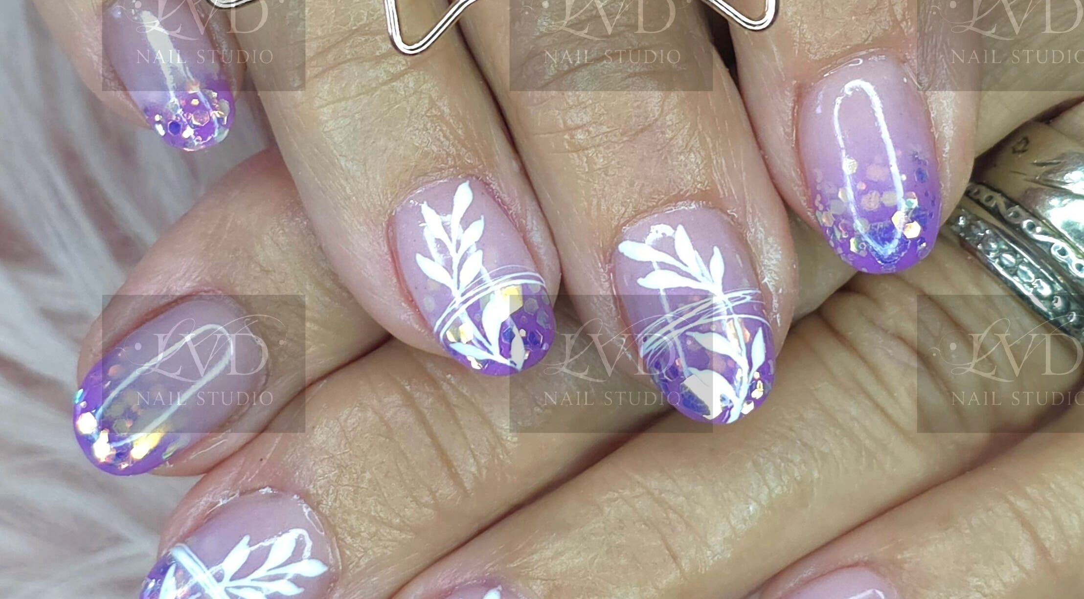 Vibrant nail art at LVD NAIL STUDIO in Pretoria, Gauteng, ZA, featuring purple and white floral design.