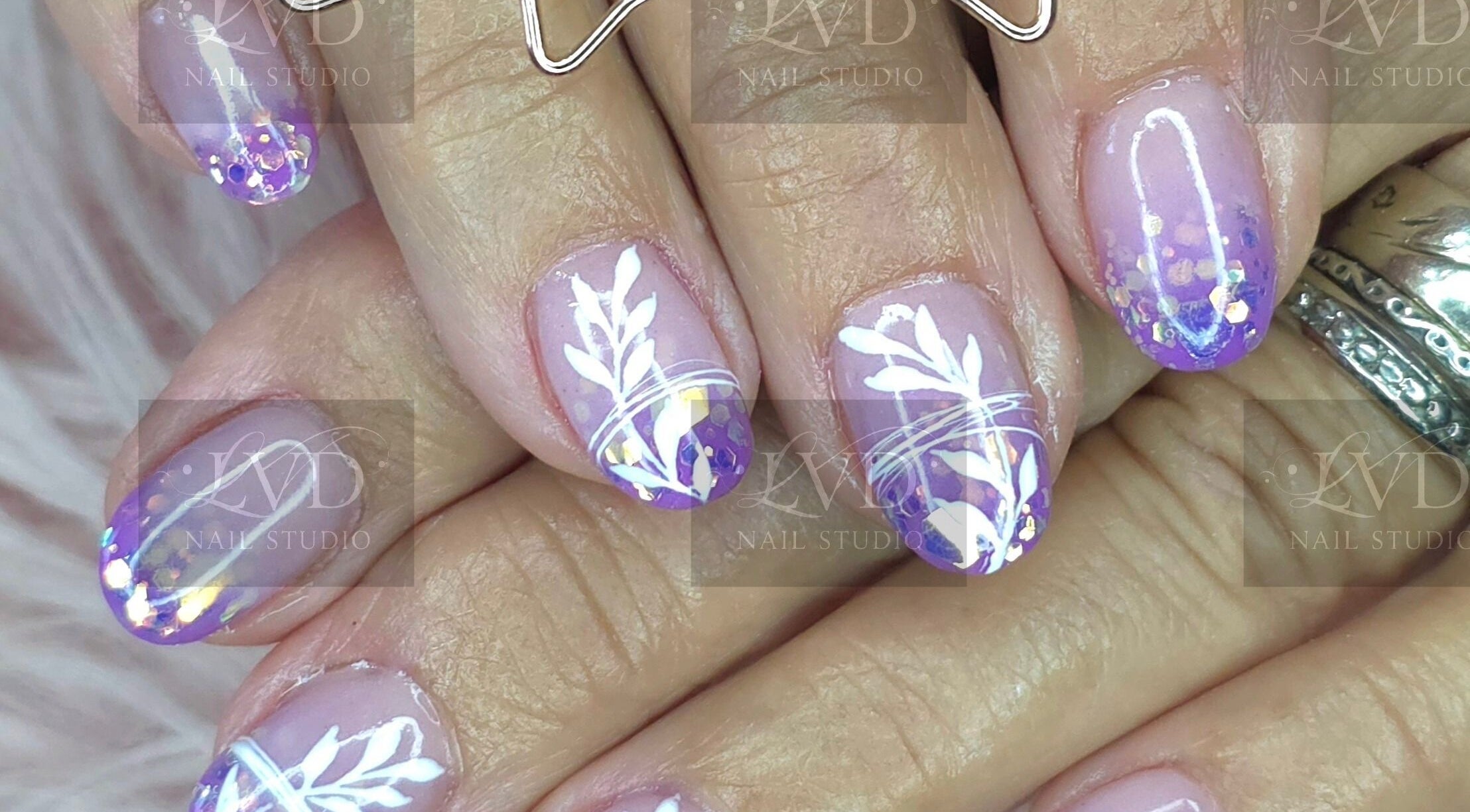 Vibrant nail art at LVD NAIL STUDIO in Pretoria, Gauteng, ZA, featuring purple and white floral design.