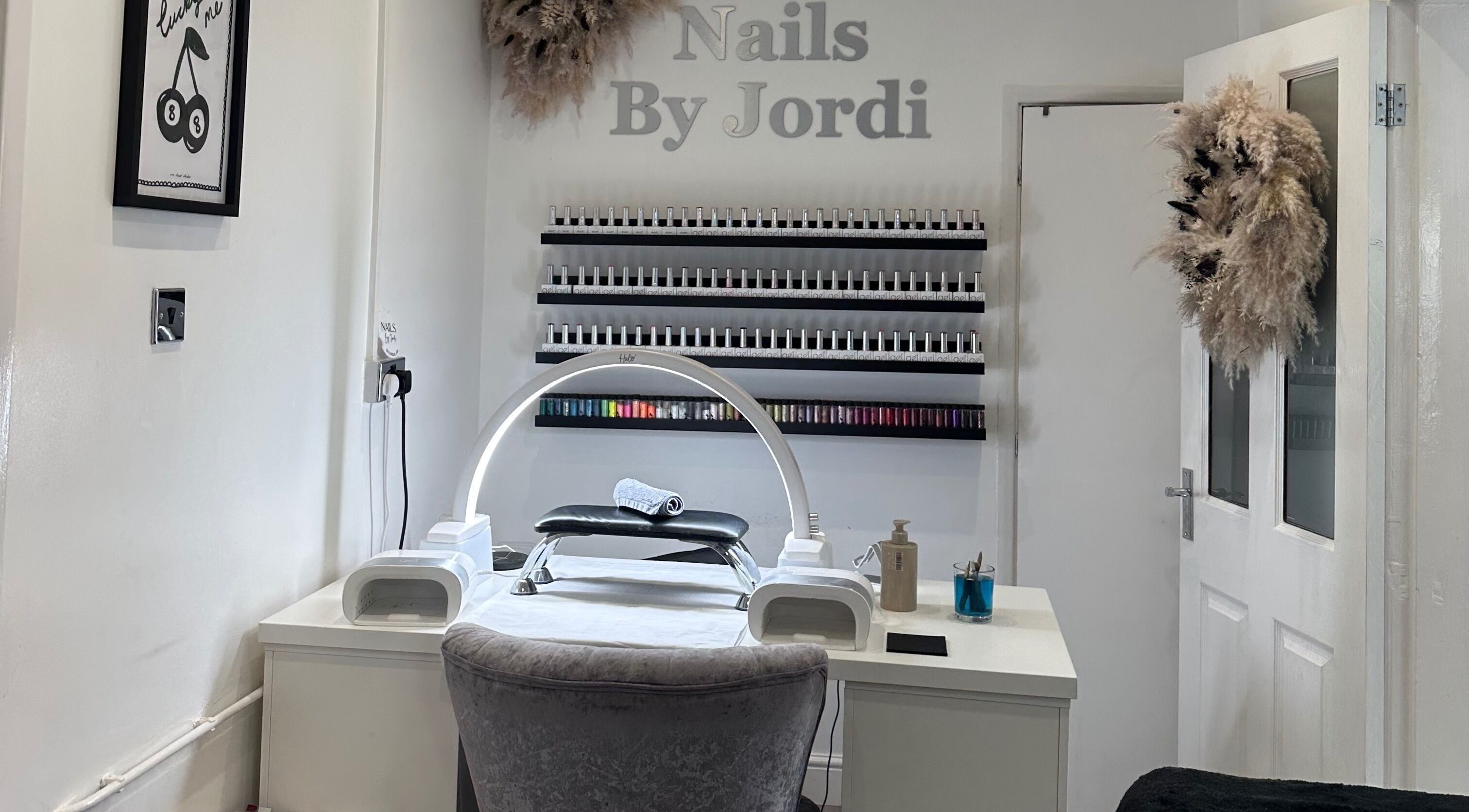 Nail station at Jordi’s Hair and Beauty in Newhall, England, GB, showcasing organized nail polish display.