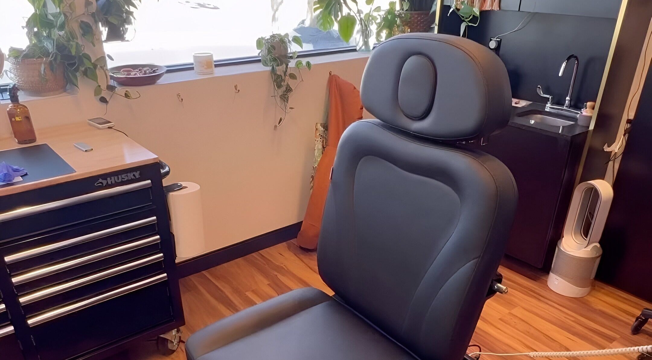 Cozy black salon chair at Wildflower Beauty Room, Clarkston, Michigan, US, surrounded by plants and decor.