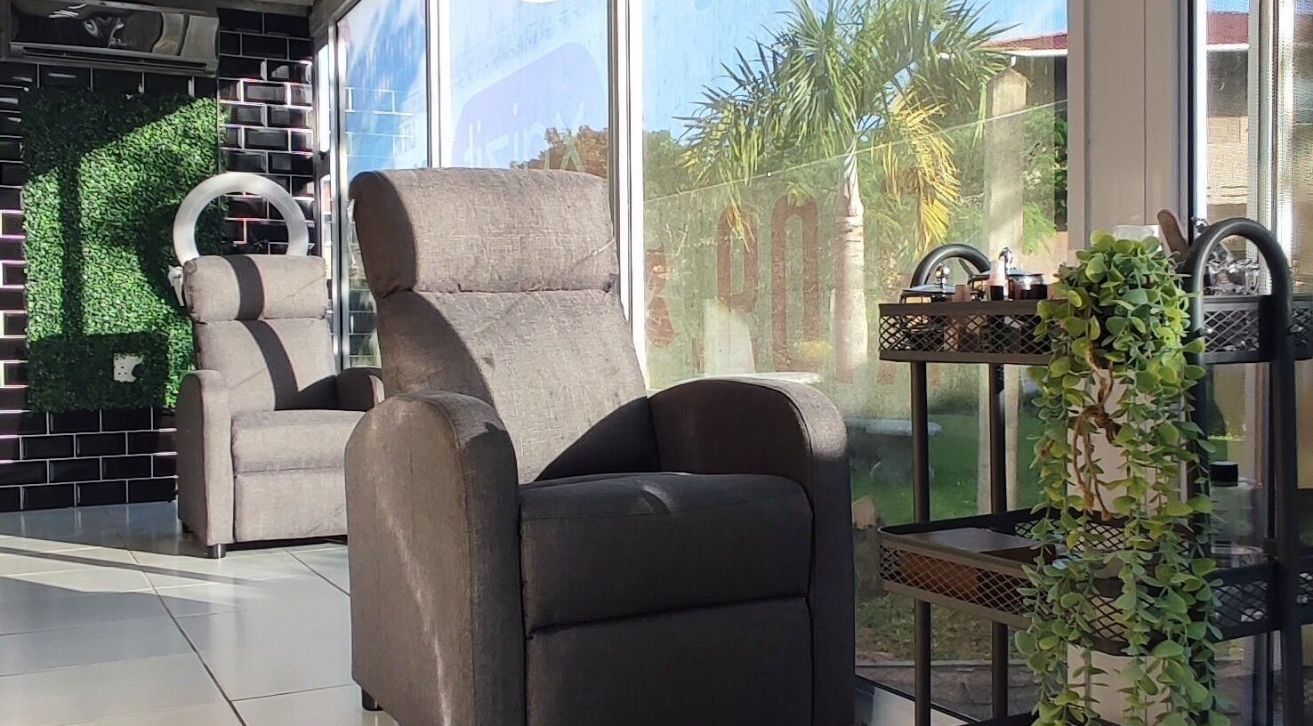 Modern lounge chairs and greenery at Xqizit Beauty Club Westville, Durban, KwaZulu-Natal, ZA.