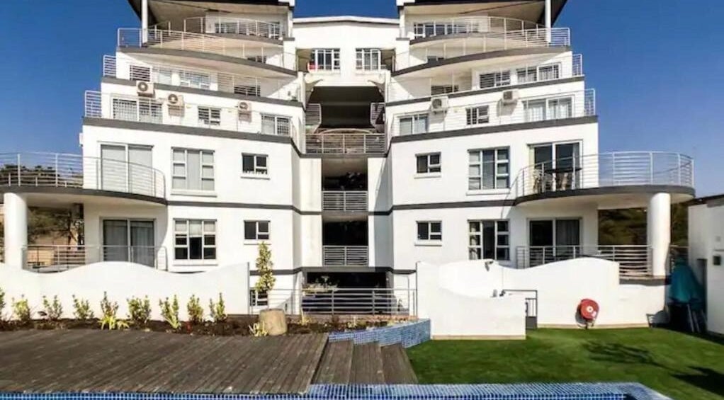 Exterior view of Nails On Ashwold in Riviera, Gauteng, ZA, showcasing a modern building with terraces.