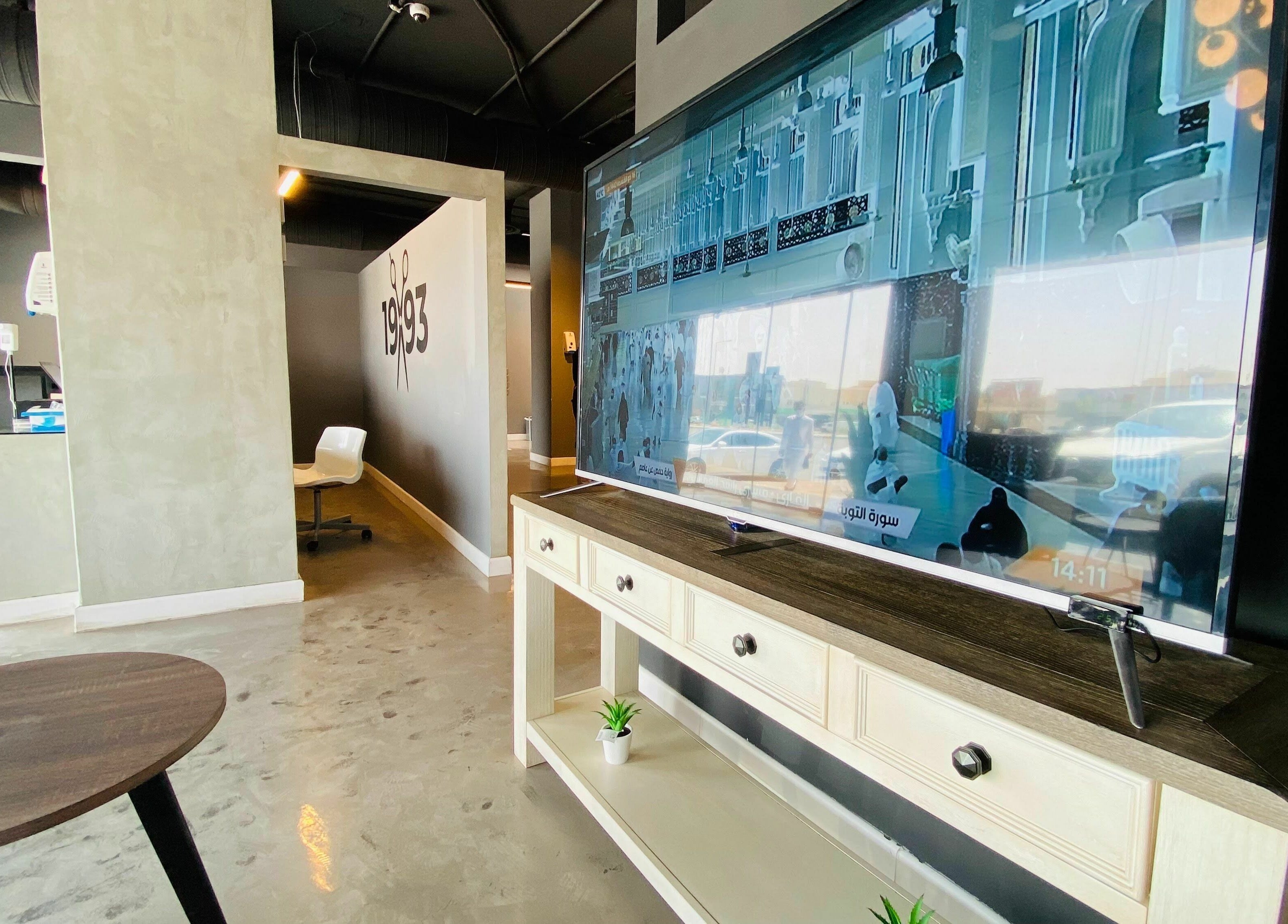 Modern interior of 1993 BARBERSHOP in Riyadh, Riyadh Province, SA with sleek design and a stylish TV setup.