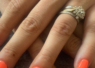 Vibrant orange manicure on hands with rings at IVY Spa and Beauté, Saint Jean D’Aulps, Auvergne-Rhône-Alpes, FR.