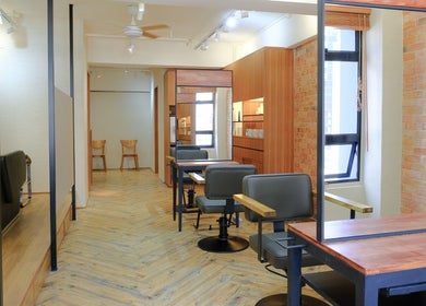Stylish salon interior at Hair Quest, Hong Kong Island, HK. Features chic chairs and rustic decor.