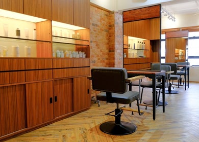 Elegant salon interior at Hair Quest, Hong Kong Island, HK, featuring modern chairs and wooden cabinetry.
