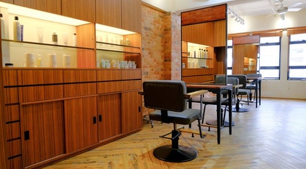 Elegant salon interior at Hair Quest, Hong Kong Island, HK, featuring modern chairs and wooden cabinetry.
