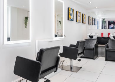 Modern salon interior at Elliott Dean, Romford, England, GB with sleek styling stations and wash basins.