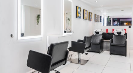 Modern salon interior at Elliott Dean, Romford, England, GB with sleek styling stations and wash basins.