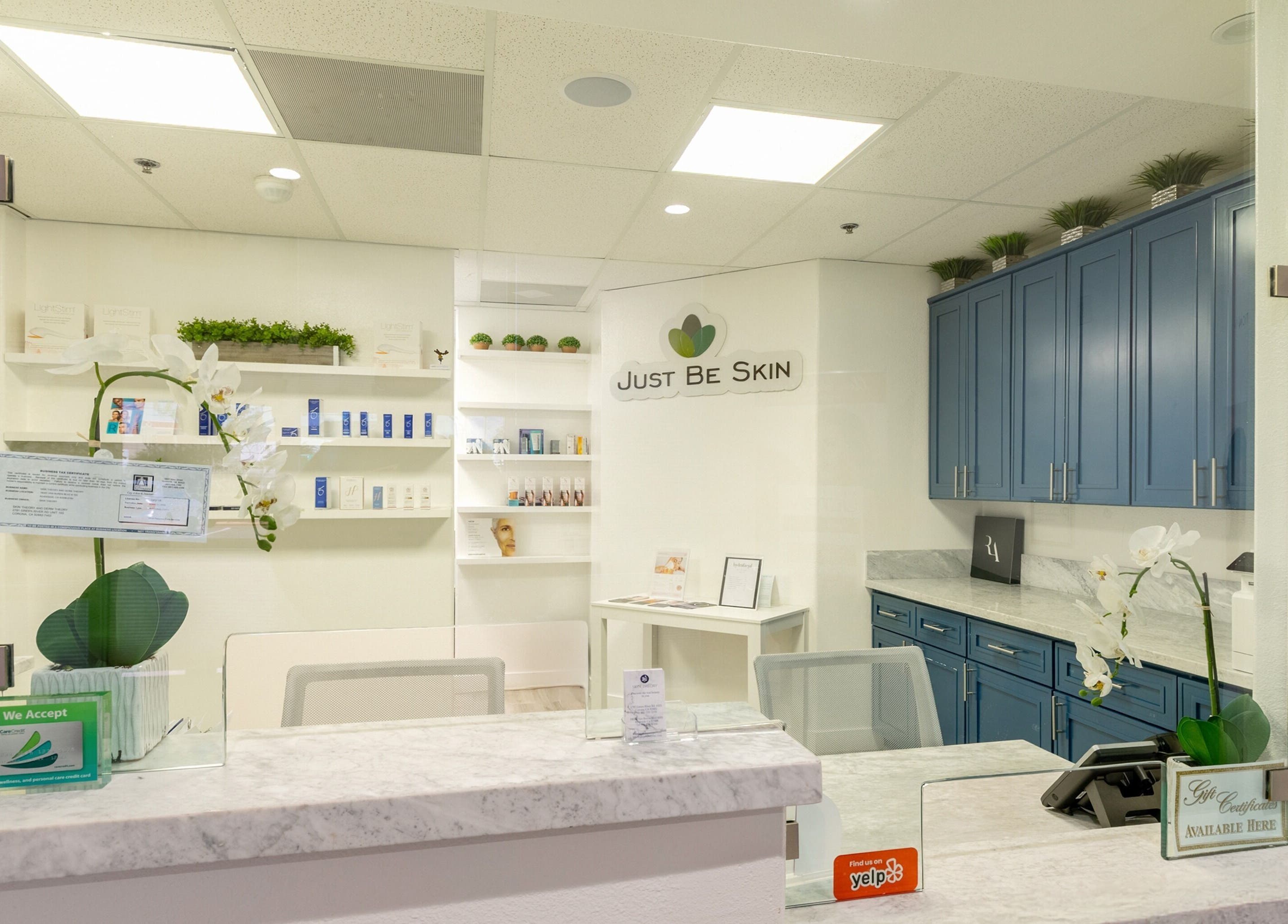 Reception desk at Just Be Skin Day Spa, Riverside, California, US showcasing products and elegant decor.