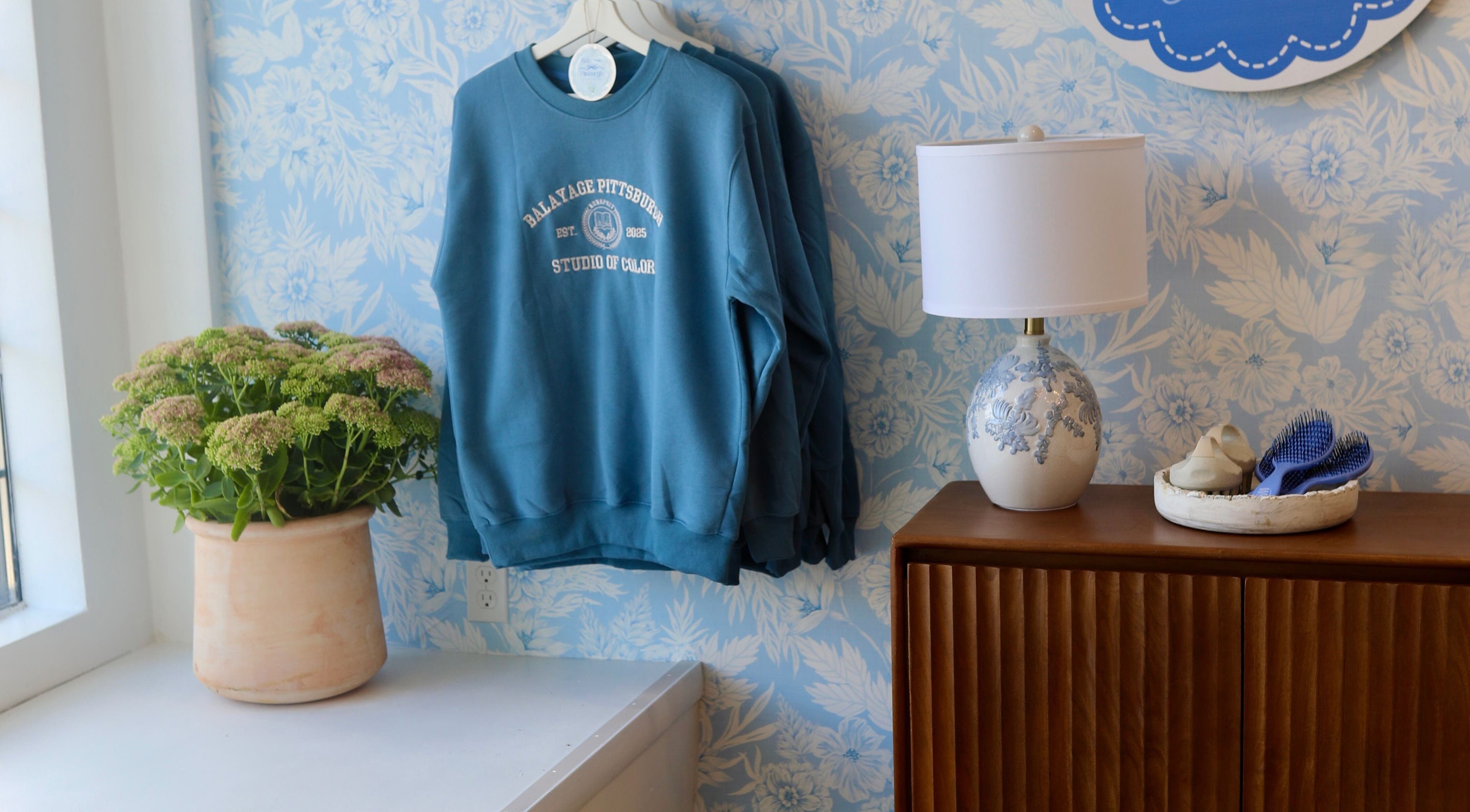 Cozy corner at Balayage Pittsburgh in Pittsburgh, Pennsylvania, US, featuring sweatshirt, lamp, and decor.