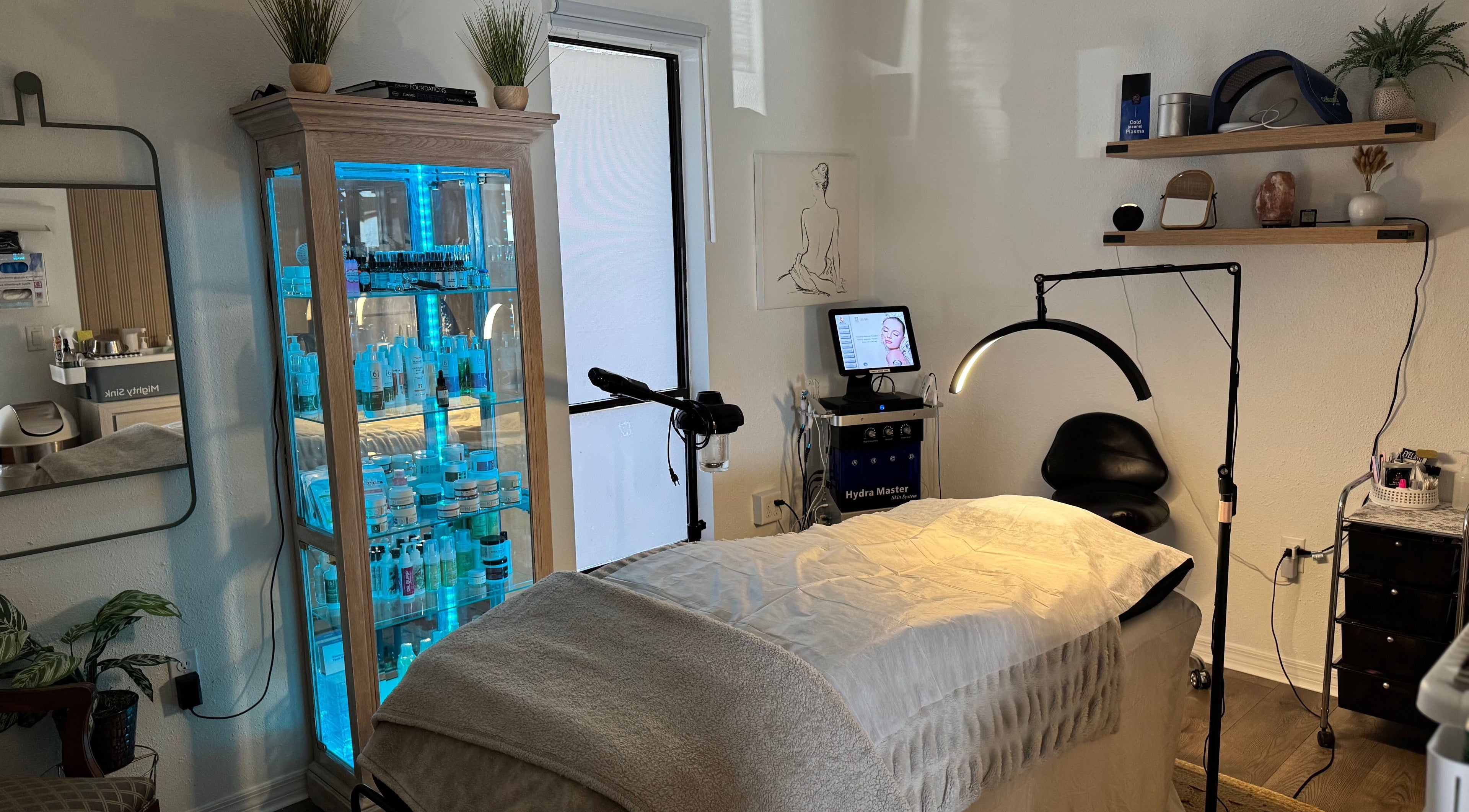 Serene treatment room at Bare Beauty Esthetics in Bradenton, Florida, US, featuring a massage table and skincare products.