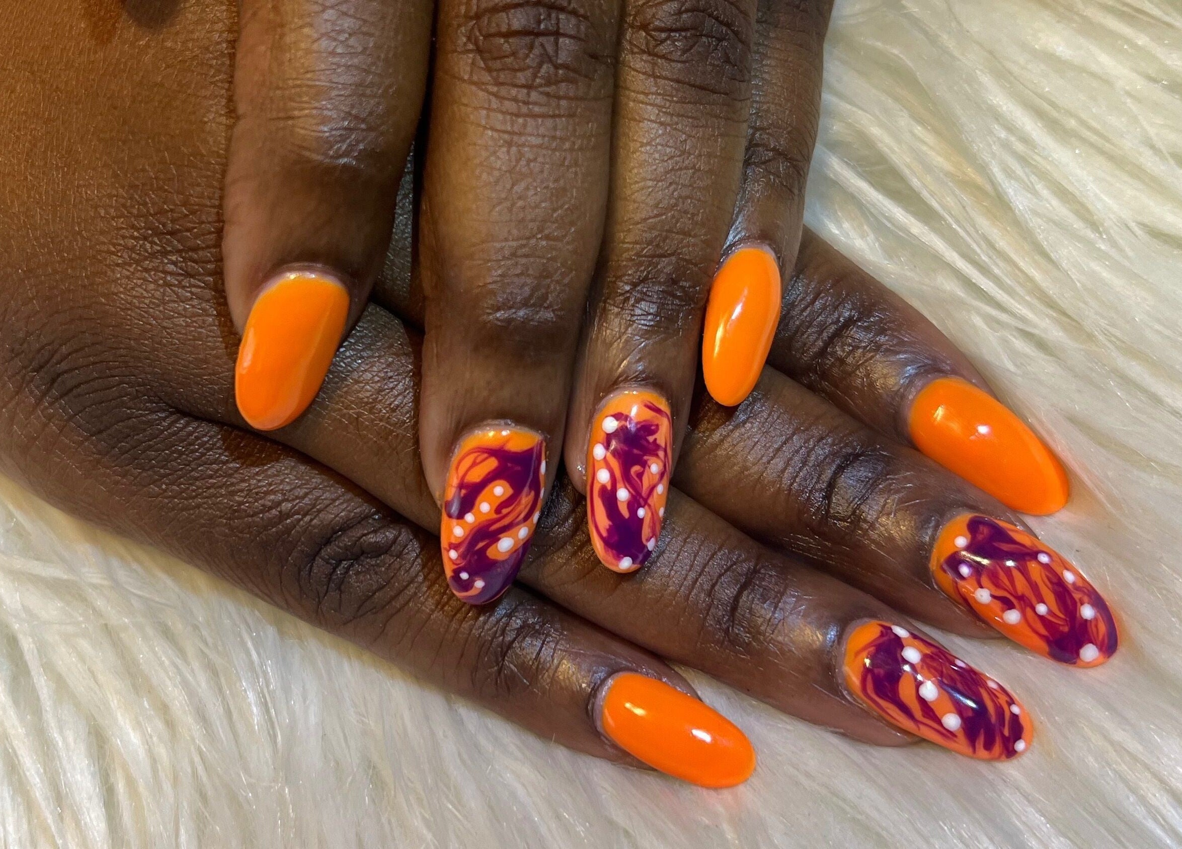 Bright orange and purple nail art at Nail Anatomy - Mobile, Stockbridge, Georgia, US, showcasing intricate designs.