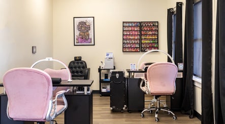 Chic nail salon interior at Nail Anatomy - Morrow in Morrow, Georgia, US featuring pink chairs and nail polish display.