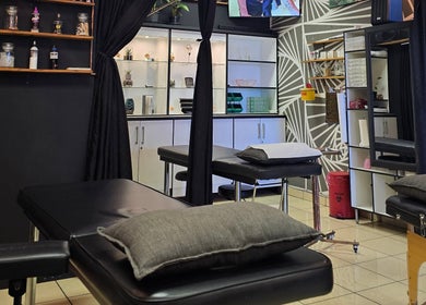Modern interior of Assari Tattoo Studio in Johannesburg, Gauteng, ZA with sleek shelves and tattoo chairs.