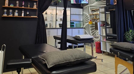 Modern interior of Assari Tattoo Studio in Johannesburg, Gauteng, ZA with sleek shelves and tattoo chairs.
