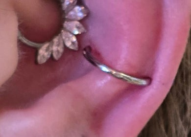 Ear with elegant hoop piercing at Assari Tattoo Studio, Johannesburg, Gauteng, ZA.