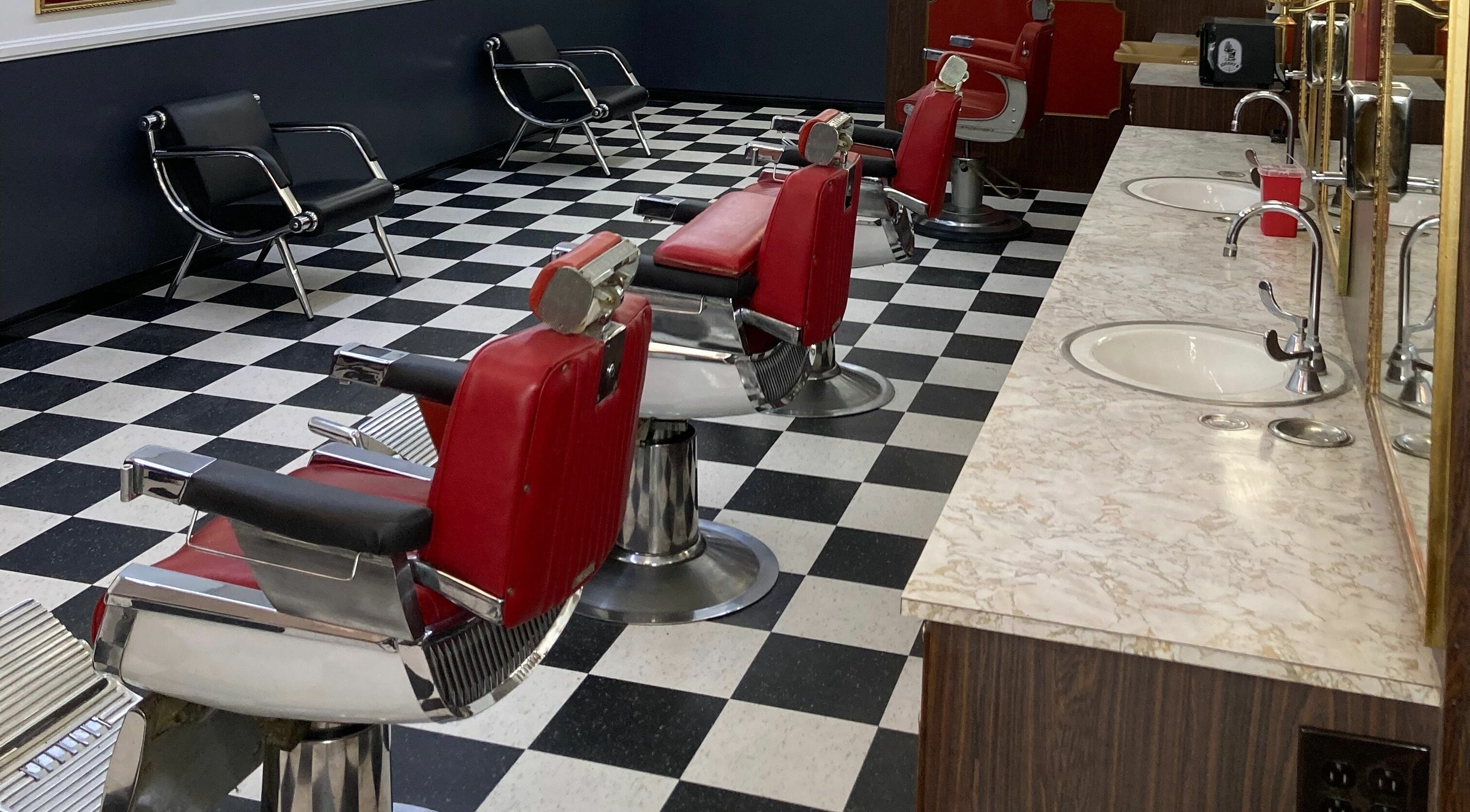 The Checkmate Barbershop in Montebello, California, US with red barber chairs and a retro checkered floor.