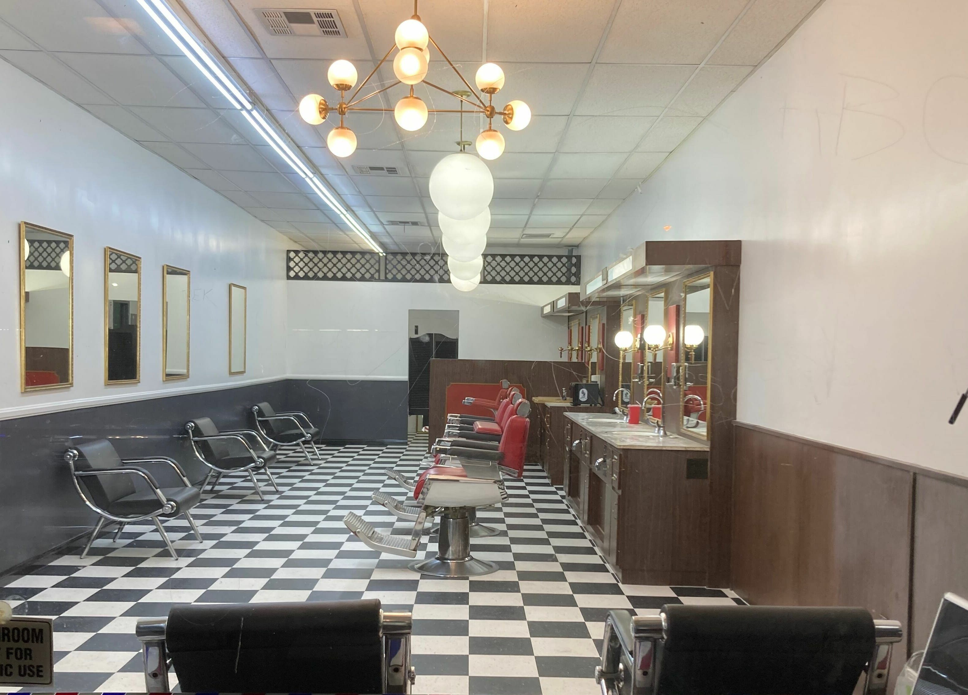 Interior of The Checkmate Barbershop in Montebello, California, showcasing classic chairs and checkered floor.
