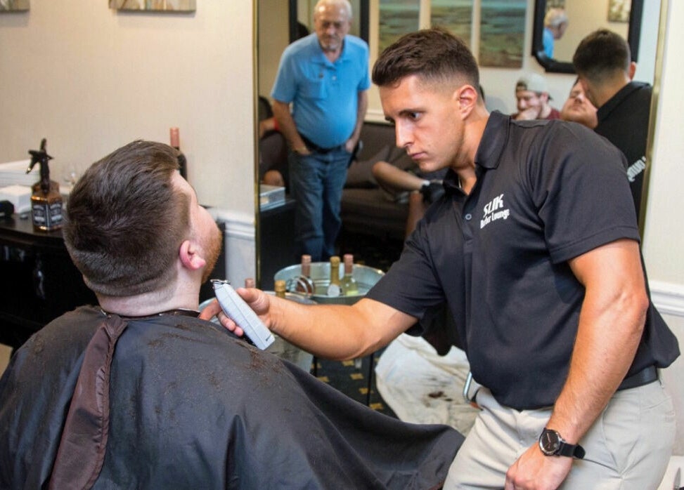 Barber expertly trims client's hair at Slek Hair Studio, Florham Park, New Jersey, US.