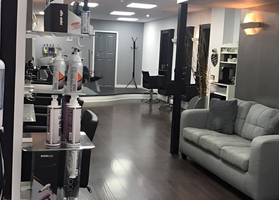 Modern interior of Laura Caroline Hairdressing in Cheadle Hulme, England, GB, featuring sleek seating and mirrors.