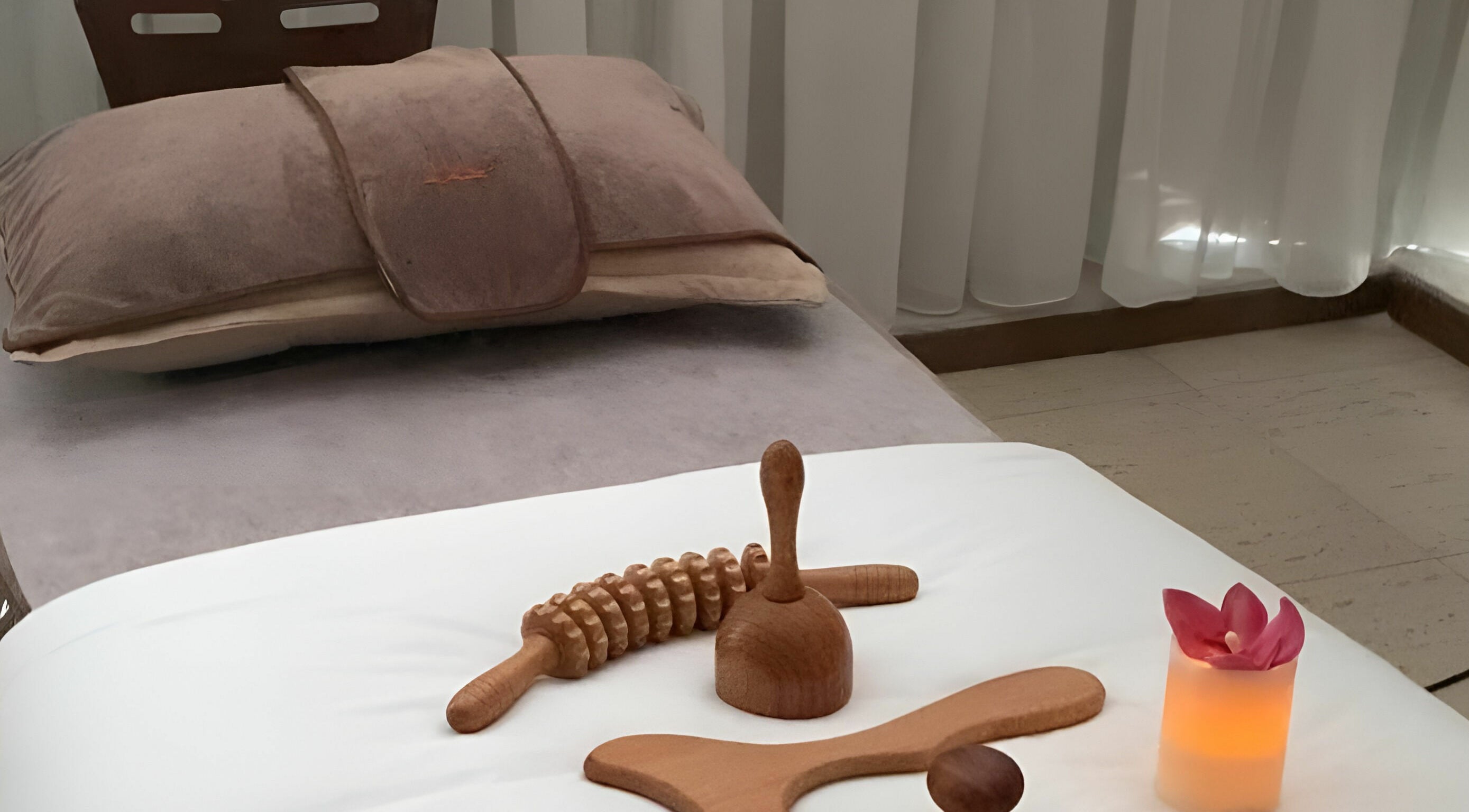 Massage tools and candle on a treatment bed at 34 The SPA, Al Khobar, Eastern Province, SA.