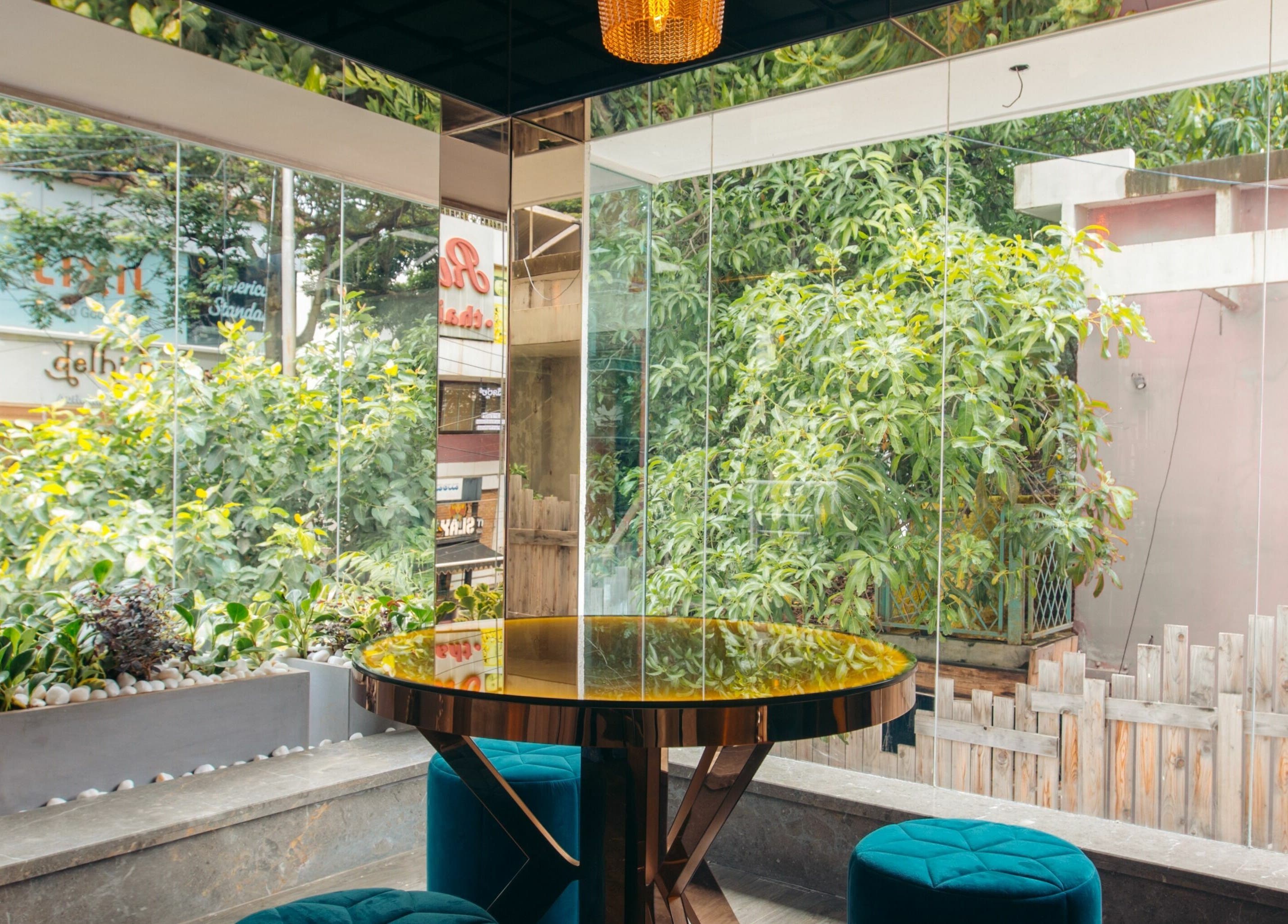 Cozy seating with lush greenery view at Blown - Salon - Indiranagar, Bangalore, Karnataka, IN.