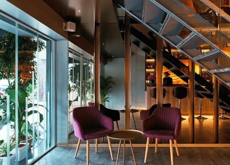 Modern interior of Blown - Salon - Vittal Mallya Road, Bangalore with purple chairs and sleek decor.