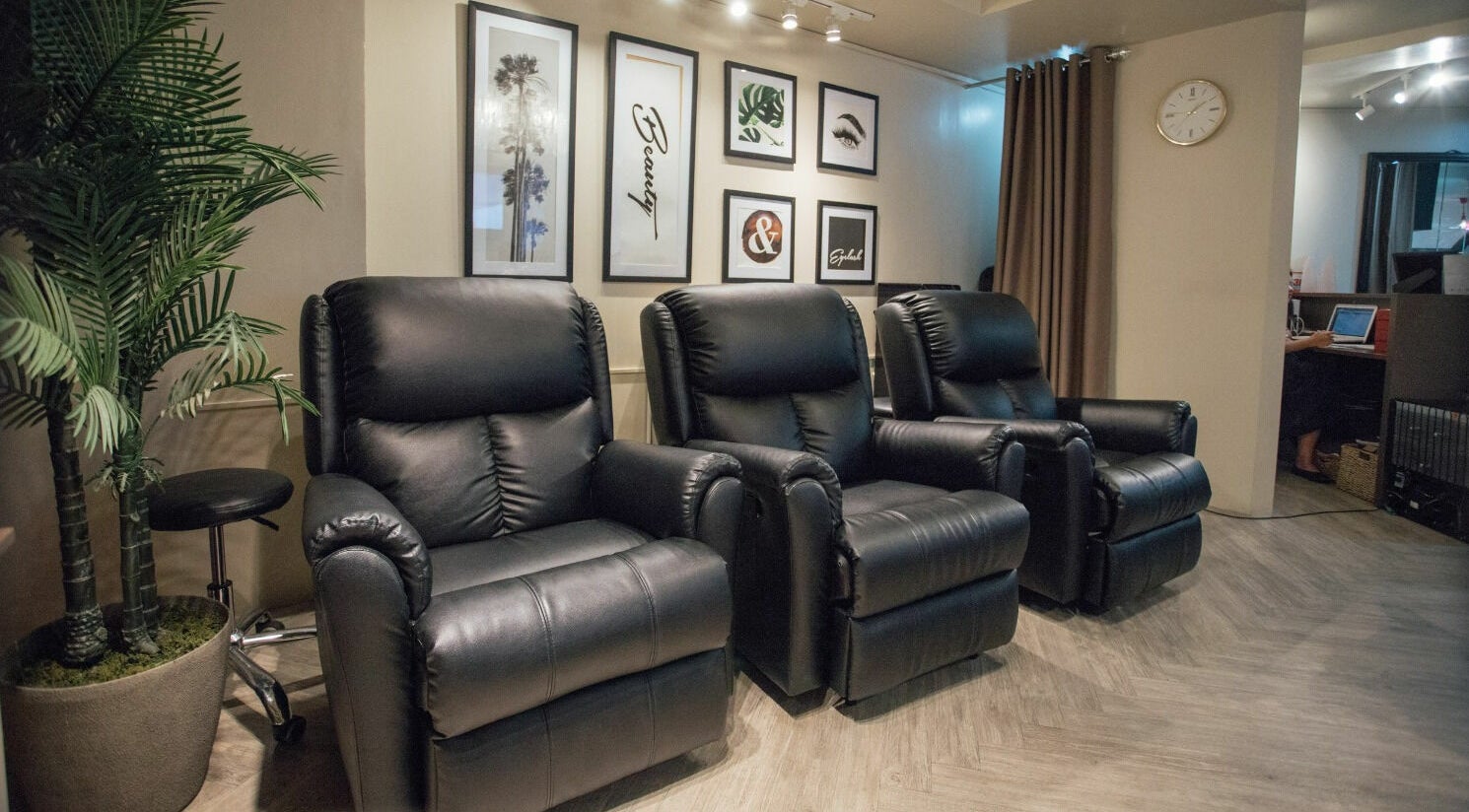 Luxurious black recliners at NEW Lounge Greenhills, San Juan, Metro Manila, PH, with elegant wall art and warm decor.