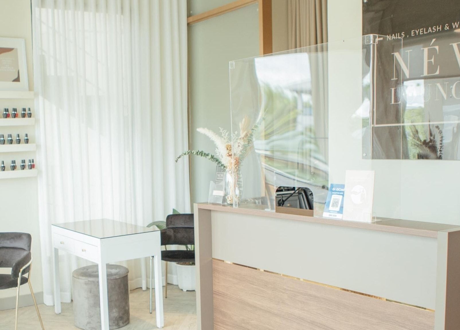 Reception area at NEW Lounge Glorietta, Makati, Metro Manila, PH, showcasing elegant decor and nail polish display.