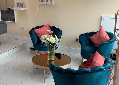 Chic seating area at Chantelle Douglas Hairdressing in Falkirk, Scotland, GB, with plush teal chairs and floral decor.