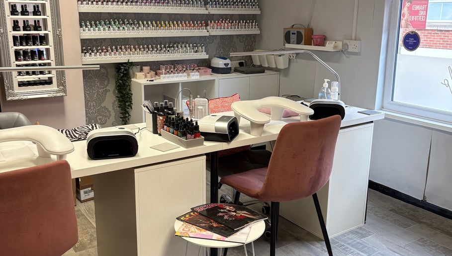 Cozy manicure station at Nails By Fiona King in Bedale, England, GB with pink chairs and nail polish display.