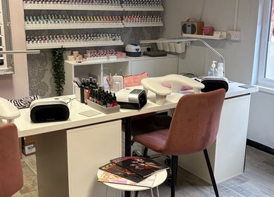 Cozy manicure station at Nails By Fiona King in Bedale, England, GB with pink chairs and nail polish display.