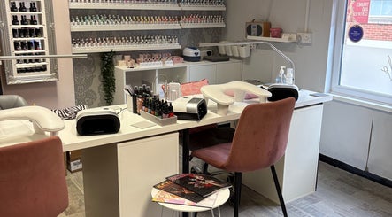 Cozy manicure station at Nails By Fiona King in Bedale, England, GB with pink chairs and nail polish display.
