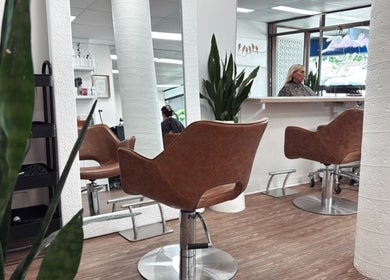 Modern salon interior at Hair by Cesca, Mooloolaba, Queensland, AU with stylish chairs and mirrors.
